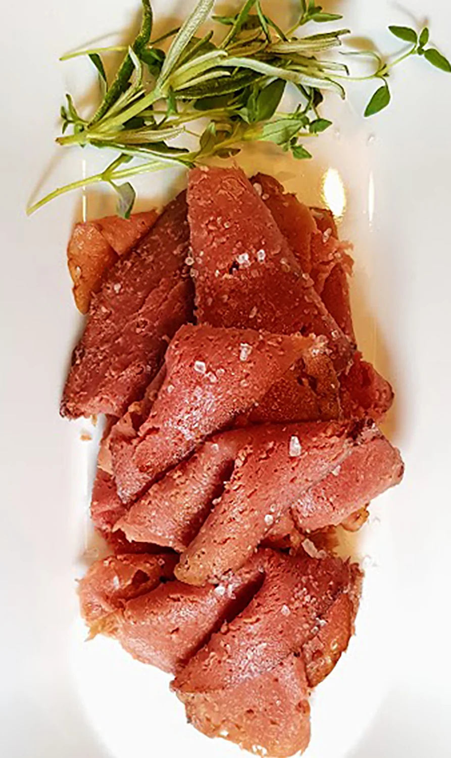 Thin plant-based roast beef slices with rosemary